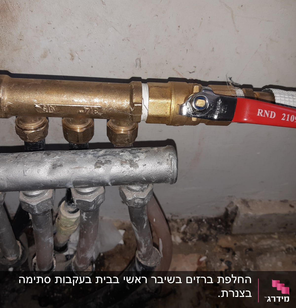 ברז פליז עם ידית אדומה וצינורות מתכת